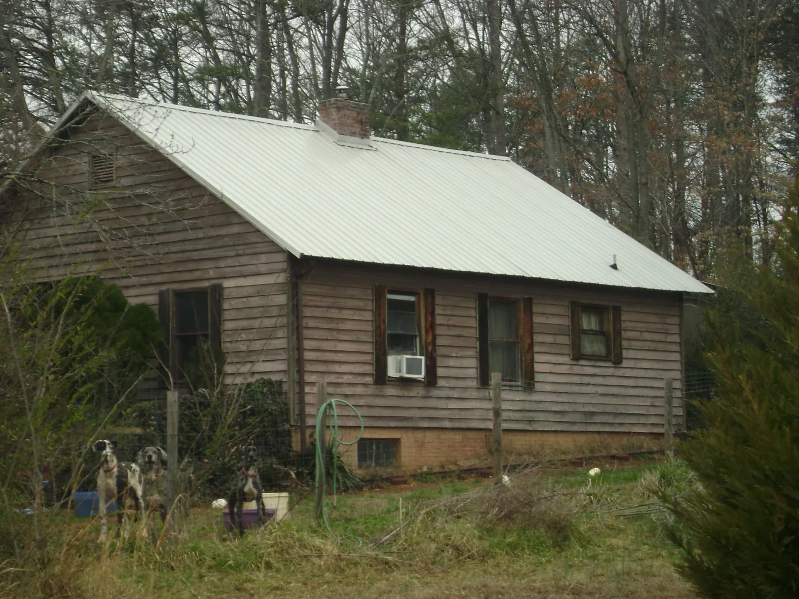 White metal roof on an old wood sided farmhouse, from a Metal Roof Installation job in Moore